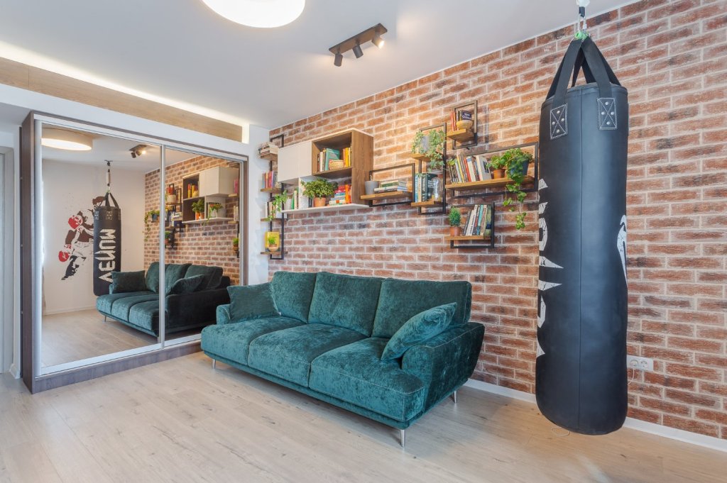 Amenajare apartament de burlac - living cu sac de box, perete caramida aparenta, canapea verde, dulap cu oglinda fumurie (1)