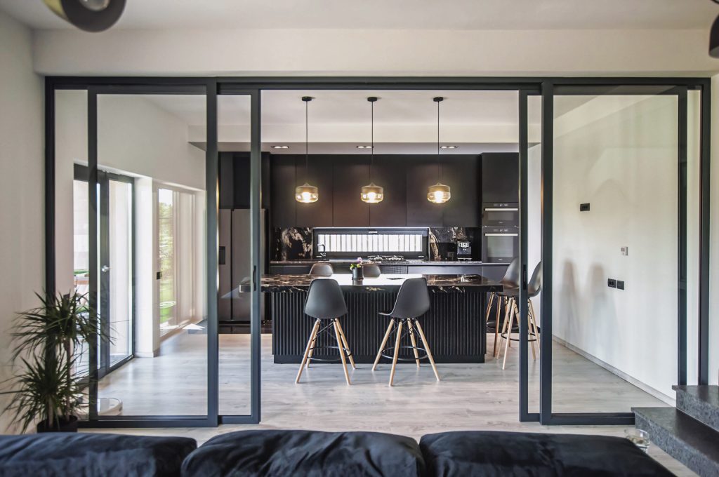 Amenajare casă Iași - decor negru modern - living separat de bucătărie cu uși de sticlă cu cadru metalic