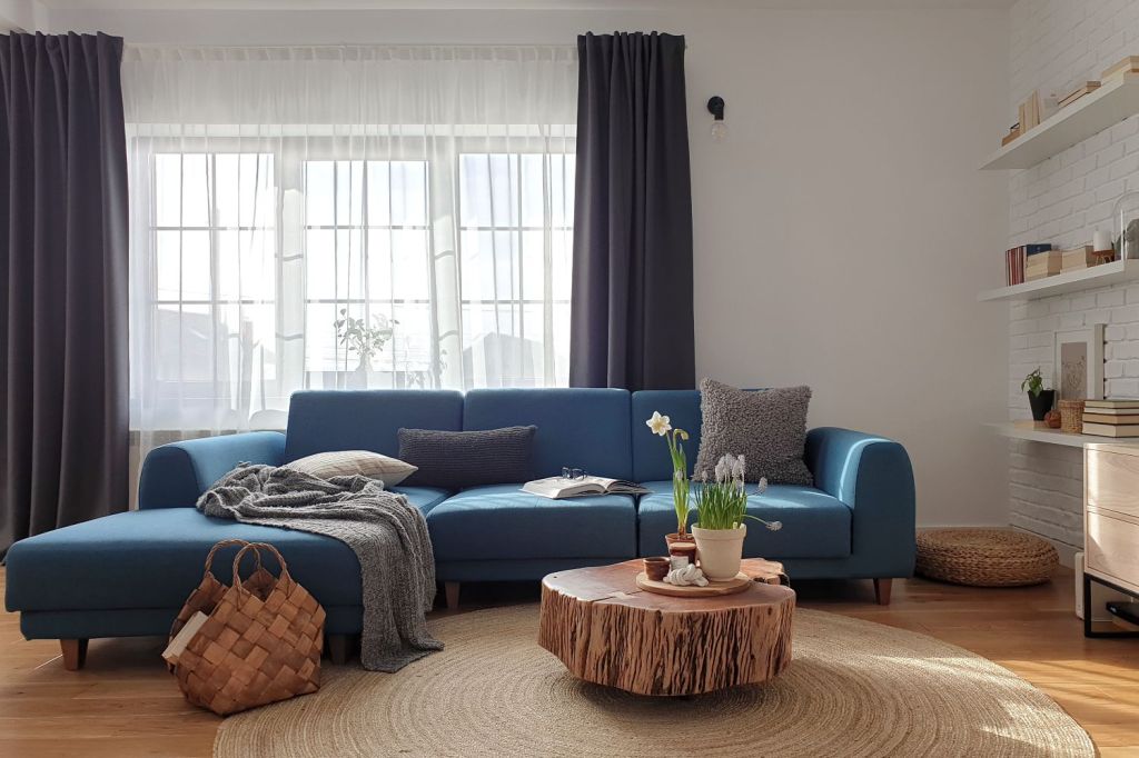casa stil scandinav culori relaxante living canapea albastru pastelat masuta de cafea trunchi copac pereti vopsiti in alb