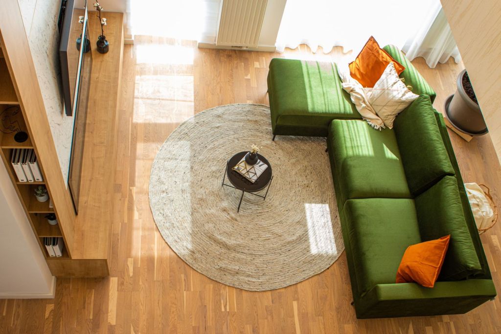 combinatii culori living amenajat cu verde oranj si finisaje lemn natur cu subton cald spatiu luminos vazut de deasupra
