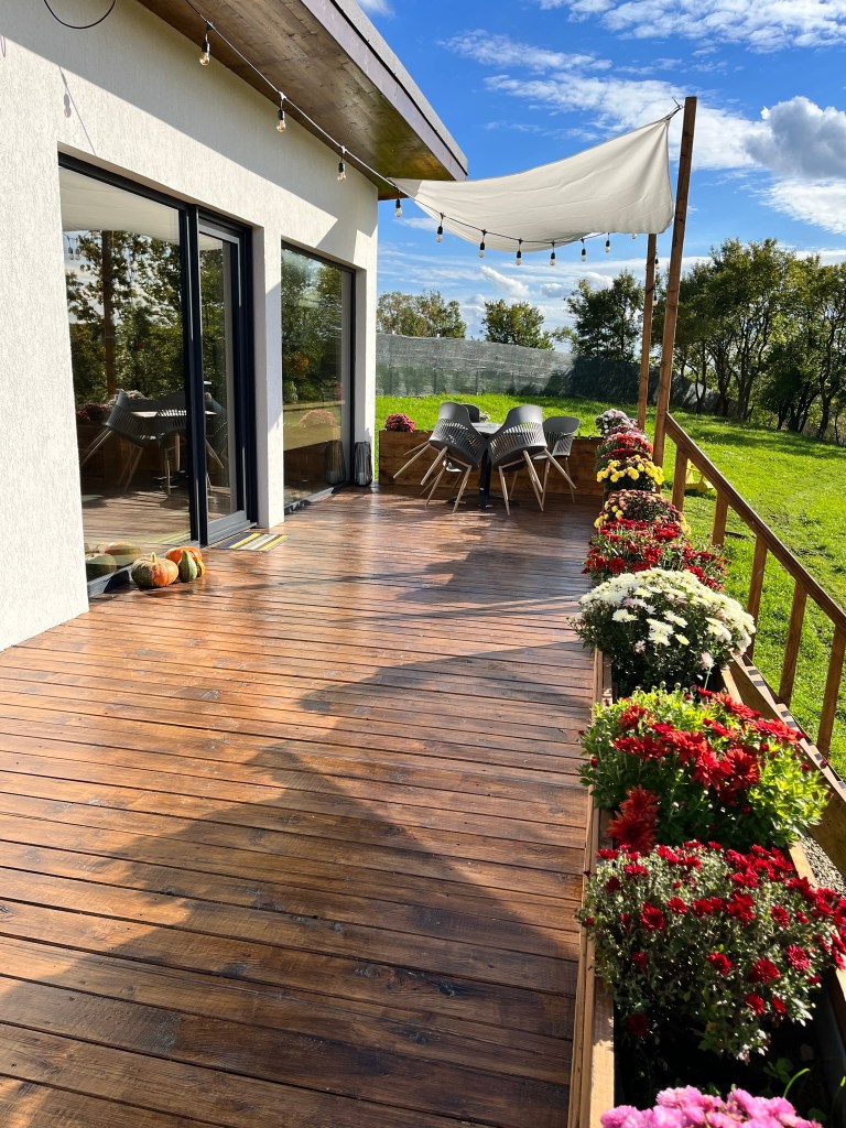Terasa de lemn are o suprafață de 30 de metri pătrați și este înconjurată de flori