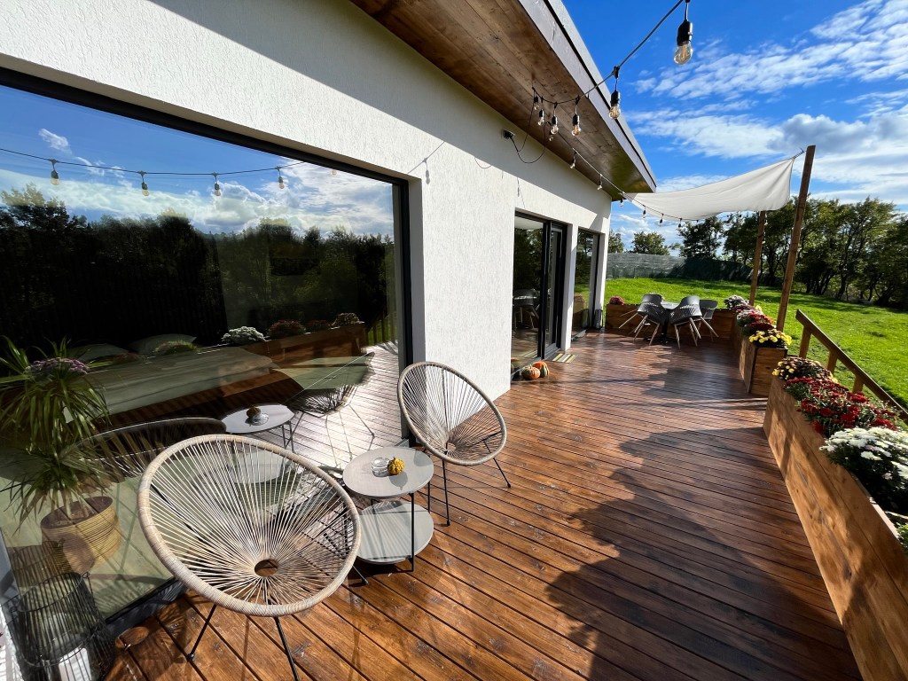 Terasa de lemn are o suprafață de 30 de metri pătrați și este înconjurată de flori