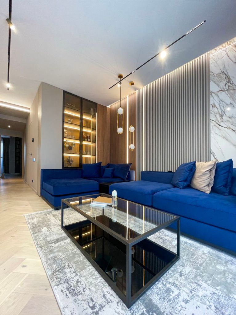 amenajare stil modern living combinatie de culori pentru albastru si gri canapea albastra covor gri pereti marmura riflaje gri lumini led