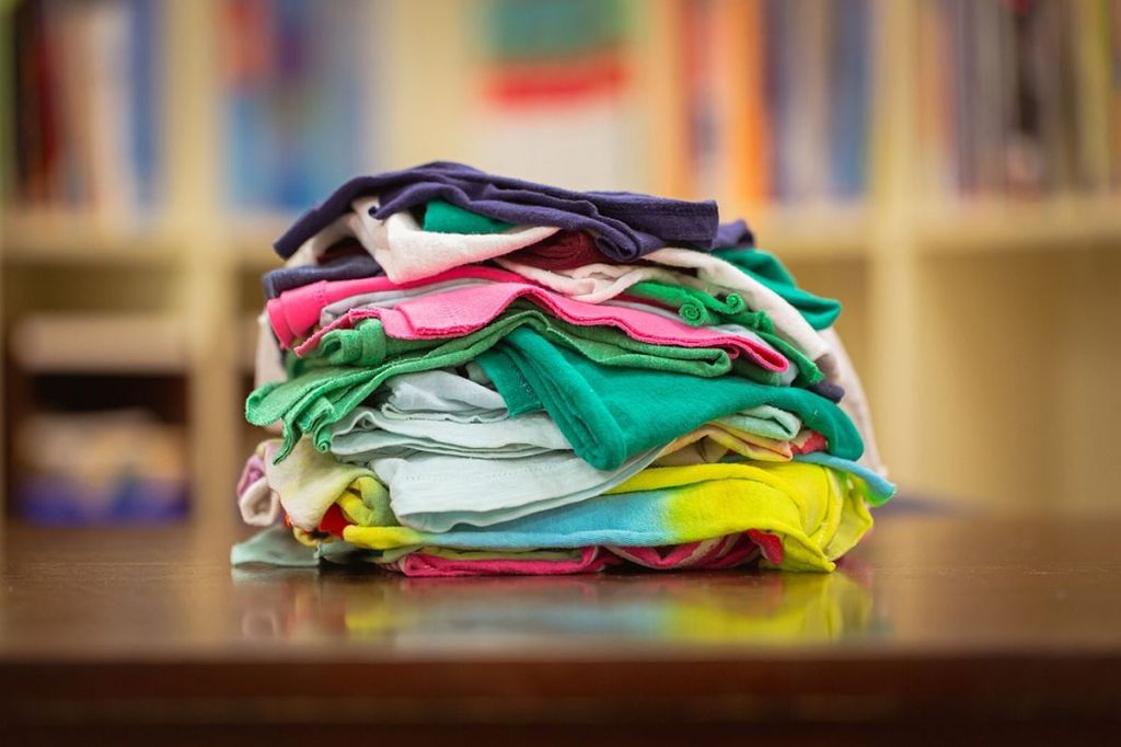 Cârpe curățenie: diverse materiale colorate pe o suprafață din lemn.