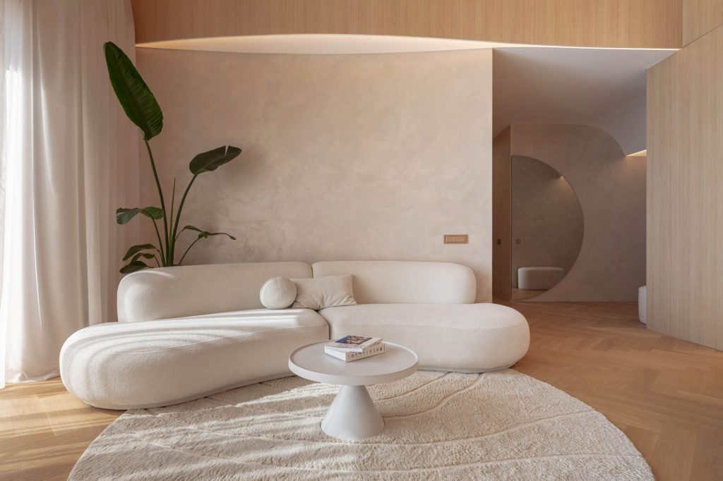 culori relaxante pentru living amenajat bej cald stil wabi sabi canapea alba covor crem planta cu frunze mari