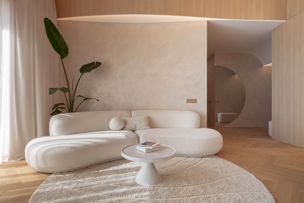 culori relaxante pentru living amenajat bej cald stil wabi sabi canapea alba covor crem planta cu frunze mari