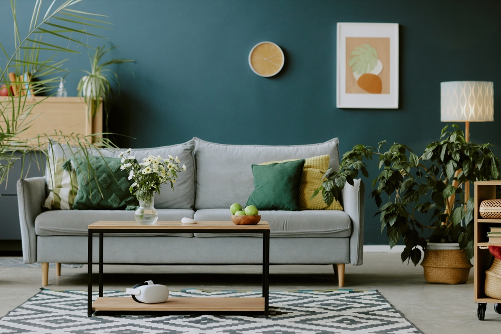 design biofilic amenajare interioara cu canapea masa din lemn si multe plante, cu perete verde