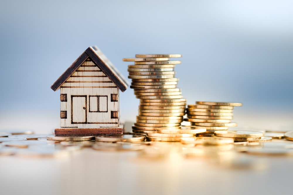 impozit locuinta 2025 casa din lemn cu gramada de monede aurii