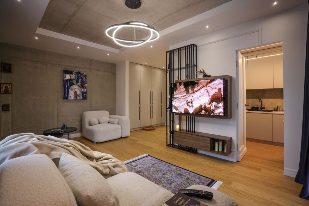 living open space bucatarie apartament andra marinescu canapea alba fotoliu beton aparent mobilier minimal