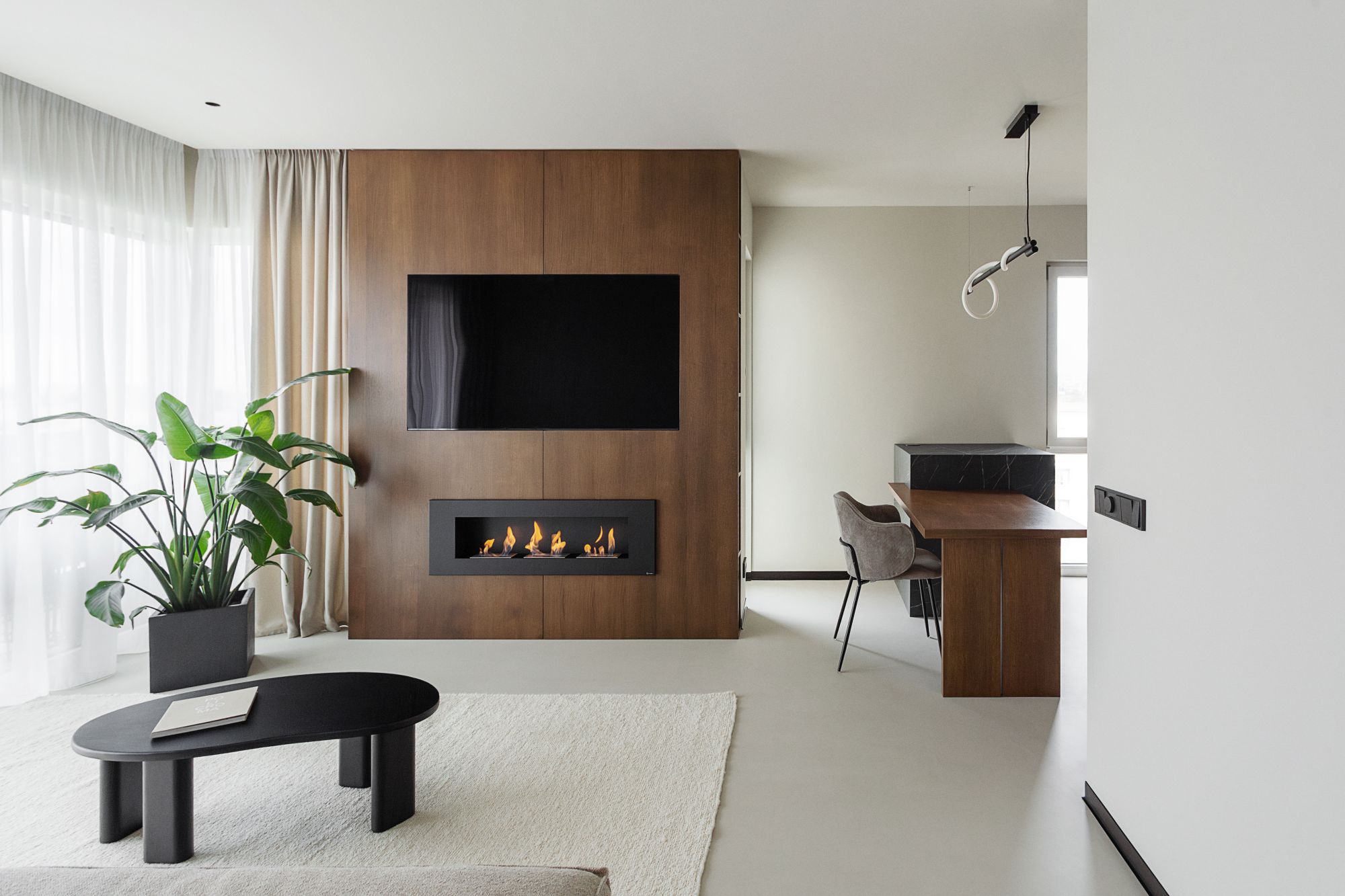 amenajare living cu design interior modern minimalist cu finisaje deschise la culoare, pardoseala gri murdar si panou de perete din lemn intunecat