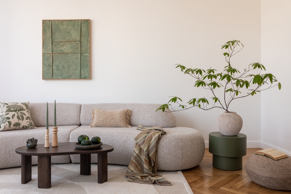 canapea gri in living pozitionare corecta cu planta si tabou si masuta de cafea
