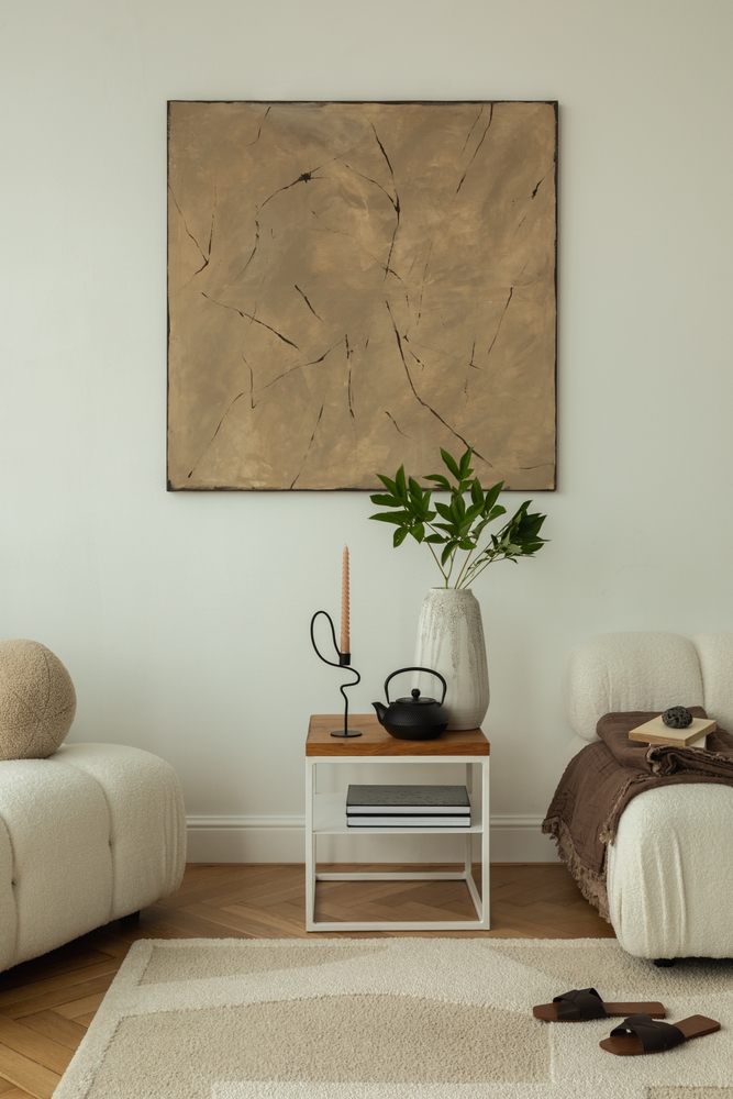 amenajare cu regula 3-5-7 in designul de interior decoratiuni asimetrice intr-un living in culori neutre cu canapea alba si un tablou ocru