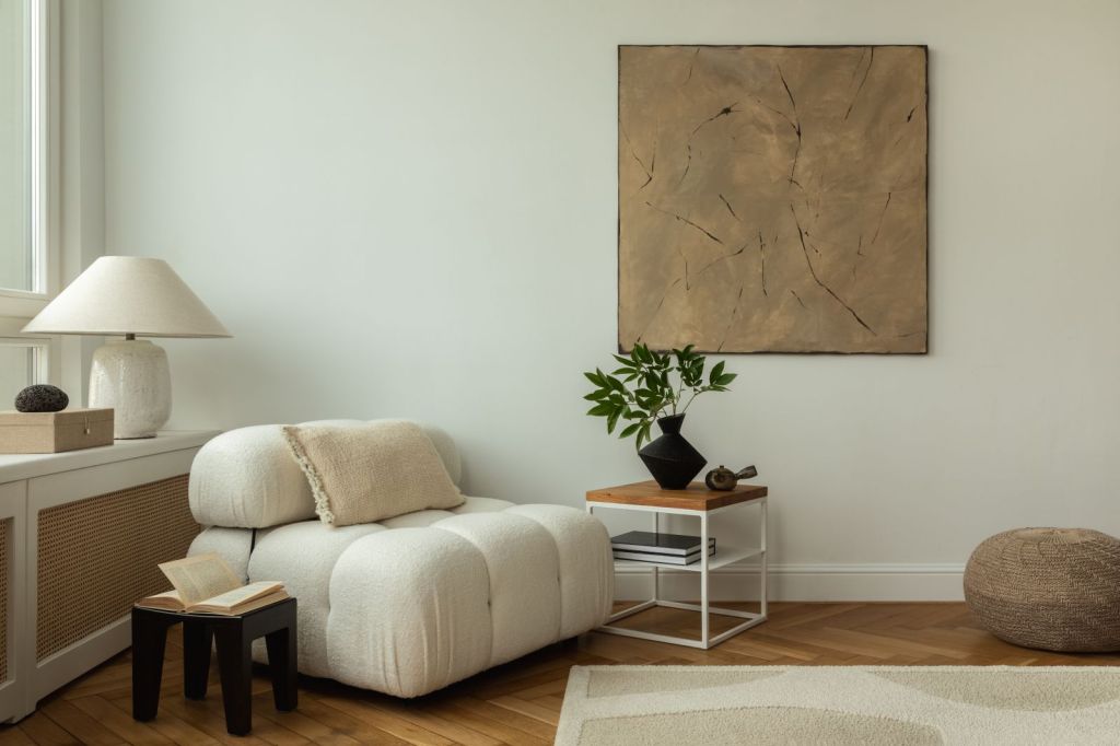 amenajare cu regula 3-5-7 in designul de interior decoratiuni asimetrice intr-un living in culori neutre cu canapea alba si un tablou ocru