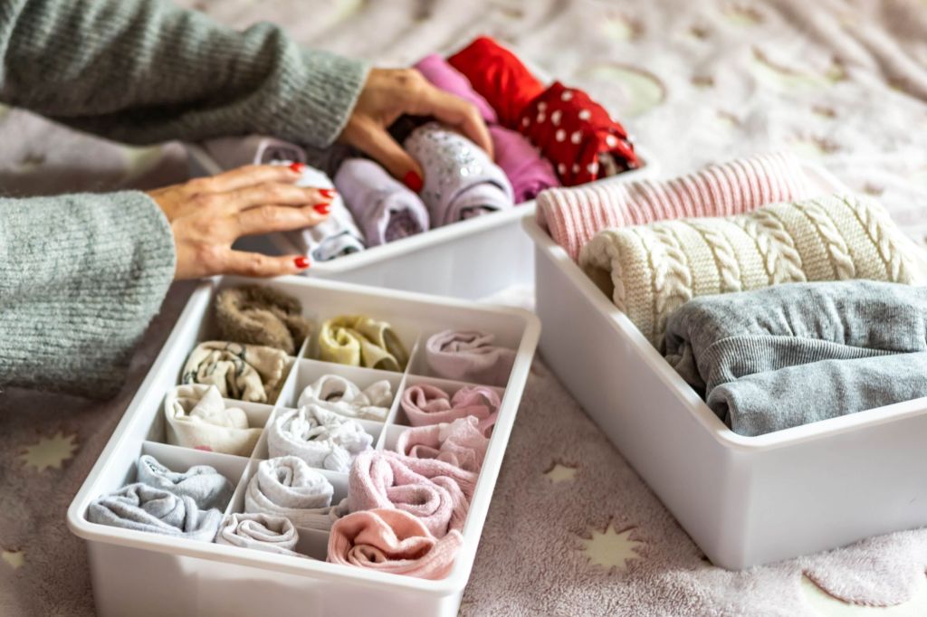 metoda japoneză de împachetat haine vertical în cutii mâini care aranjează pulovere sosete lenjerie intima