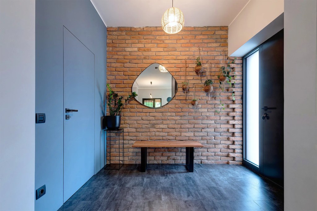 amenajare moderna hol caramida aparenta pereti albastri plante