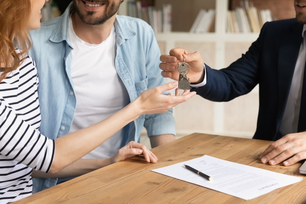cuplu proprietar si coproprietar primesc cheile la apartament de la agentul imobiliar