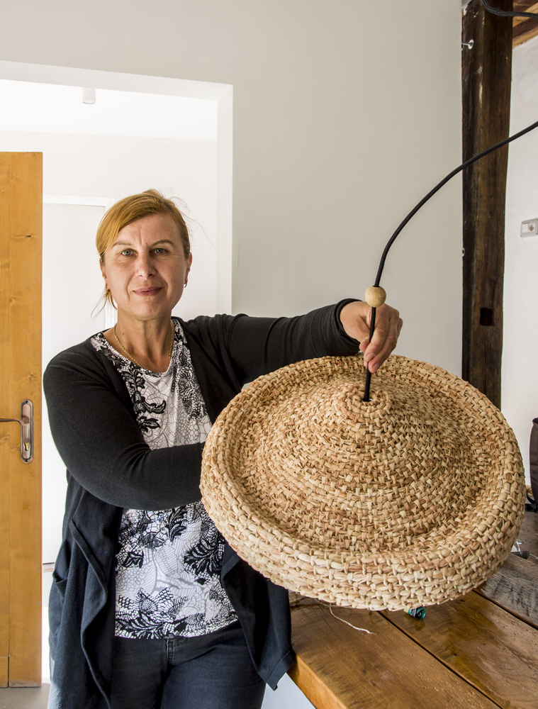 Abajurul de deasupra mesei a fost confecționat manual din foi de porumb de o localnică