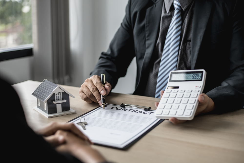 contract semnat pentru închiriere locuinta cu mențiune despre suma de plata afișată pe calculator