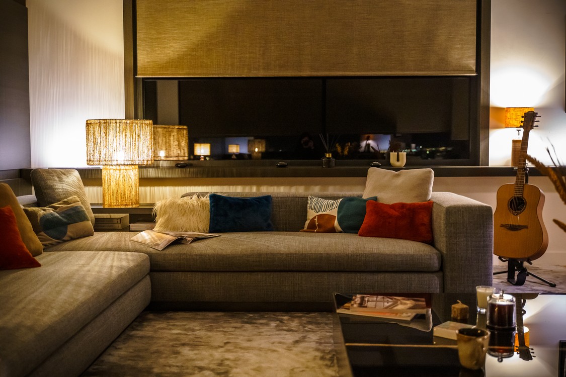 solutii hi tech tehnologie smart pentru economie la facturi living cu coltar si jaluzele motorizate lampi aprinse lumina smart