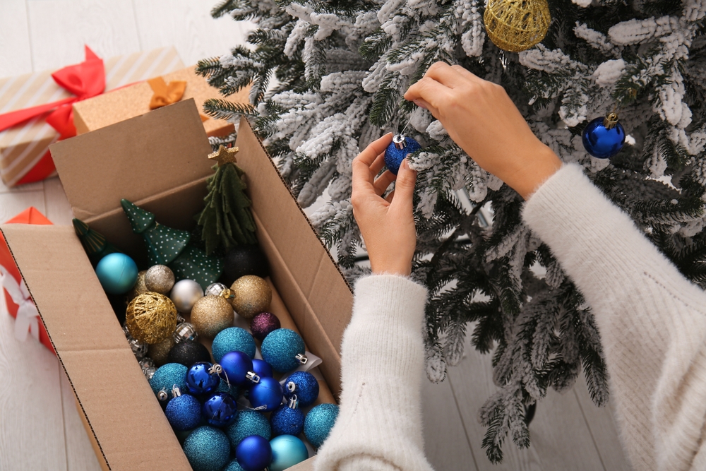 femeie care depozitate globurile de craciun într-o cutie de carton