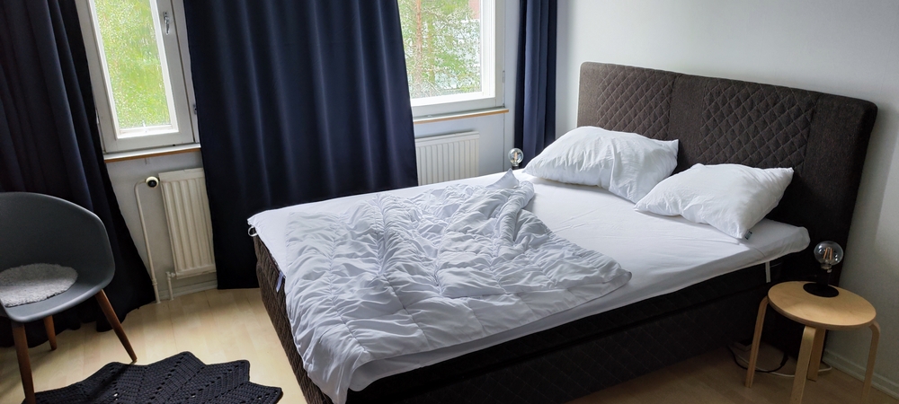 trucuri casă caldă calorifer acoperit de draperii albastre intr-un dormitor cu pat dublu deranjat