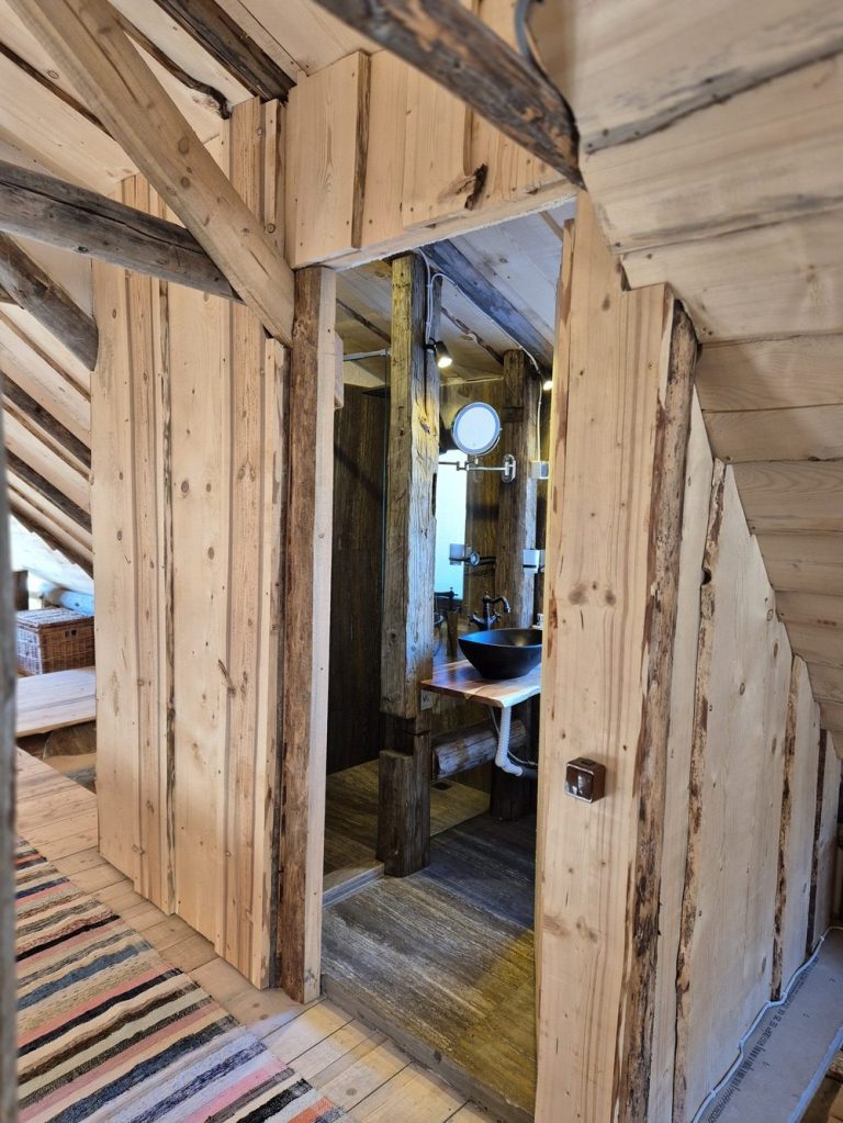 Baia de la etaj a fost una dintre provocările proiectului. Este amplasată pe buștenii care leagă cele două dormitoare