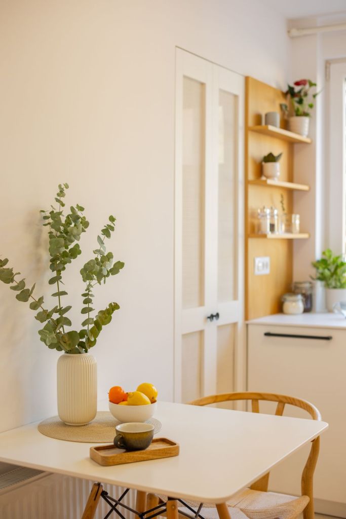 amenajare bucatarie cu alb si furnir de stejar corpuri de depozitare in forma de L si masa cu doua scaune