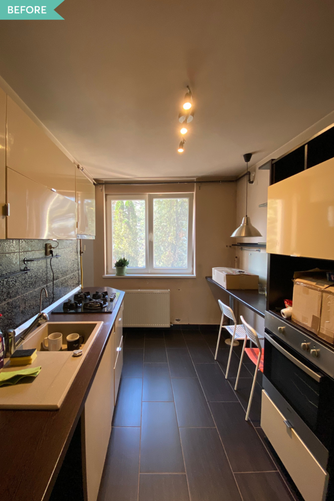 amenajare bucătărie anii 2000 cu gresie si faianta neagra mobilier crem lucios si blat maro inchis