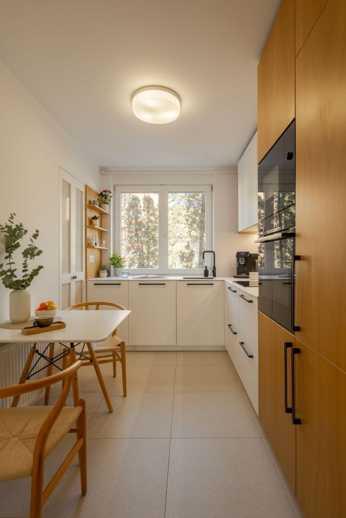 amenajare bucatarie cu alb si furnir de stejar corpuri de depozitare in forma de L si masa cu doua scaune