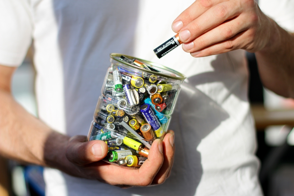 reciclare baterii uzate ținute de barbat într-un recipient special