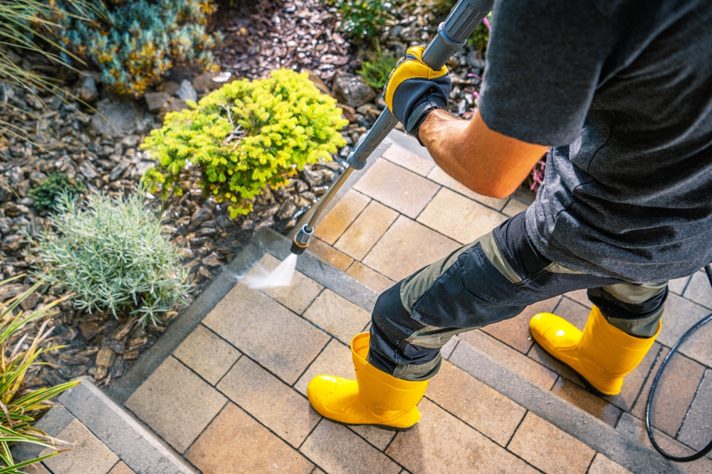 bărbat curată cu apa cu presiune scările pavate din curte