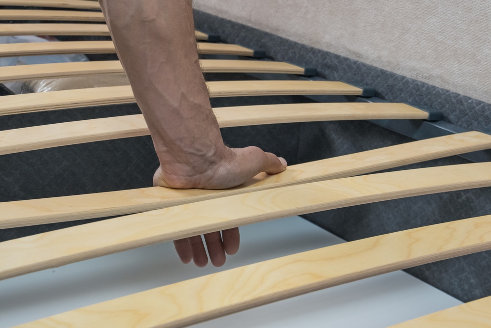 somiera flexibilă lamele apăsate de mana bărbat 